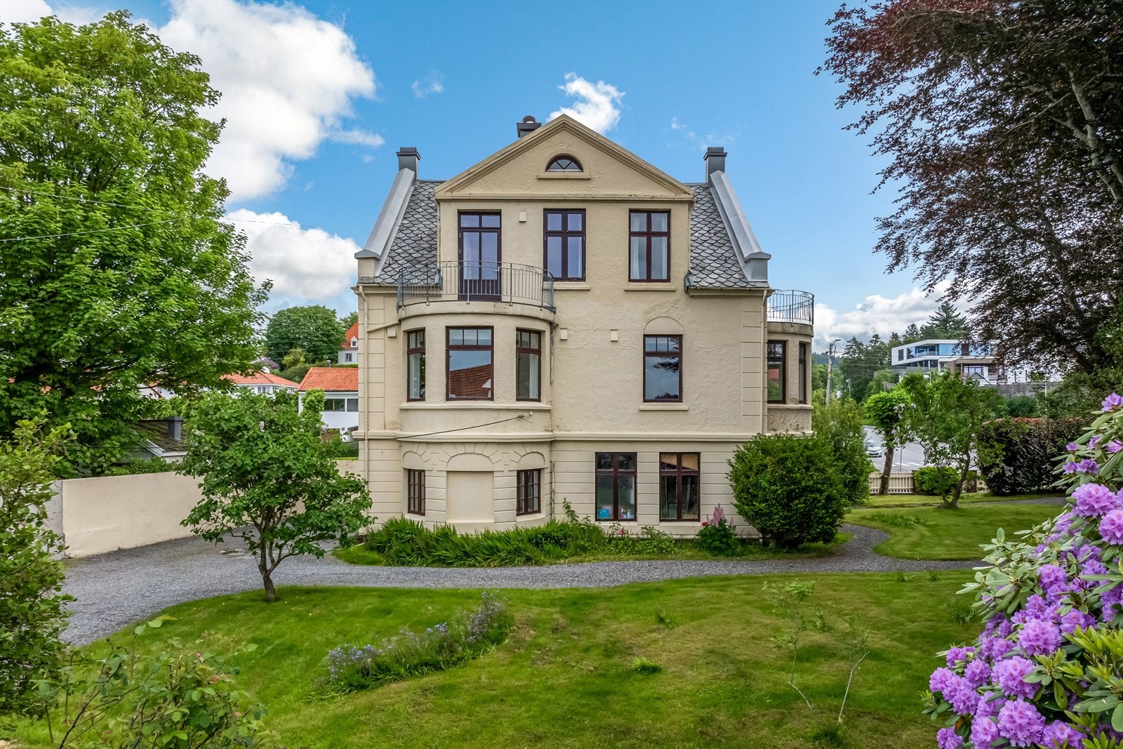 Eiendommen tilbyr stor, frodig og skjermet uteområde med ulike beplantninger, gangstier og trær Galleribilde