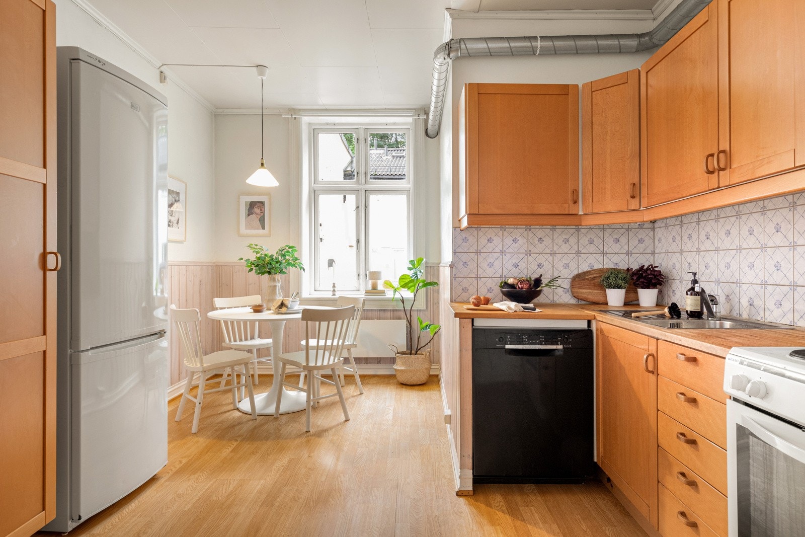 Stort kjøkken med naturlig lysinnslipp og plass til spisebord Galleribilde