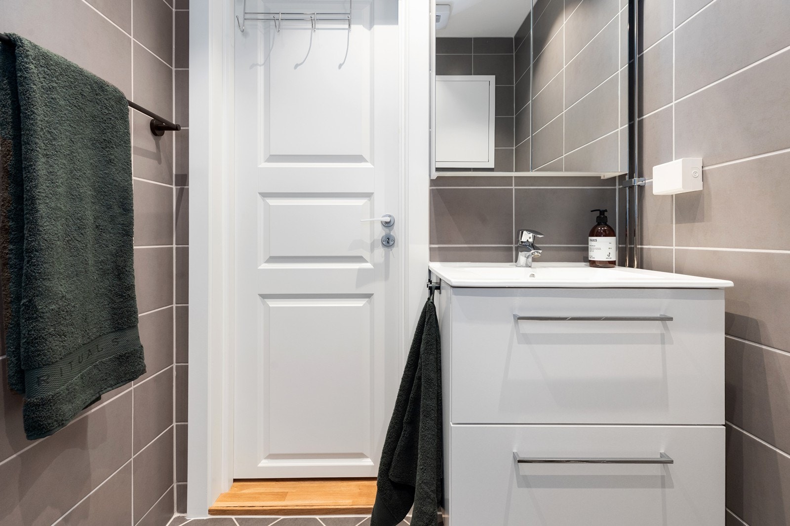 Moderne innredning med skuffeløsning, heldekkende servant og overskap med speildør. Vegghengt toalett og dushjørne med innfellbare vegger. Galleribilde