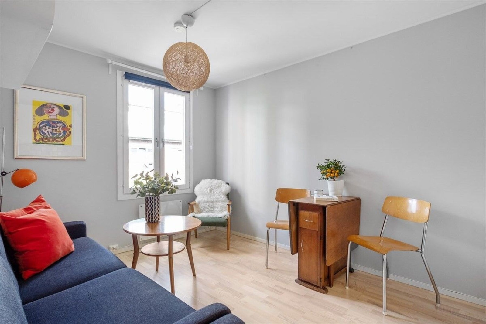 Stuen får rikelig med naturlig lysinnslipp fra et stort vindu, noe som skaper en luftig og åpen følelse i rommet. Galleribilde