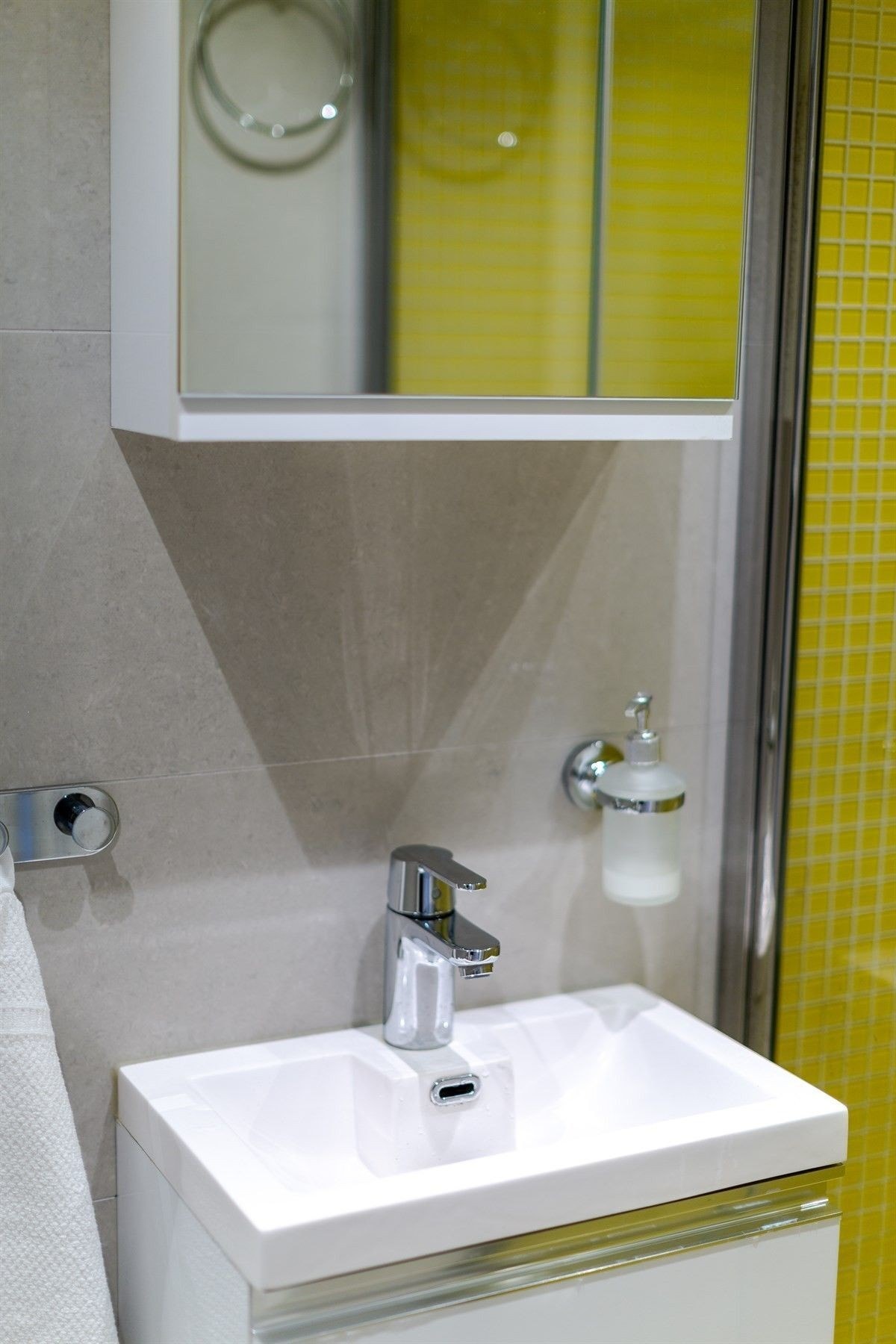 Badet fremstår stilrent med flislagte overflater og behagelig gulvvarme. Galleribilde