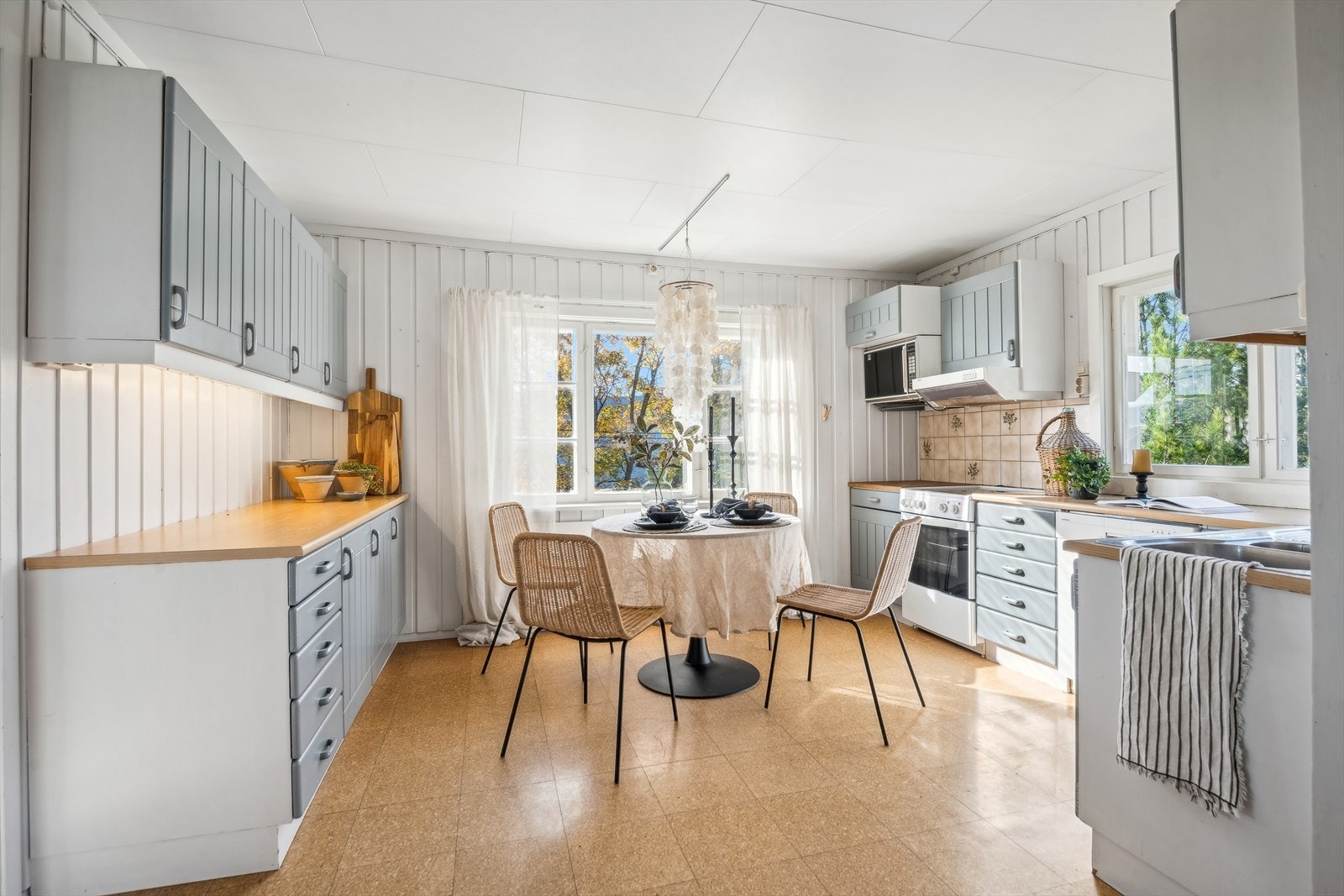 Kjøkken med malte fronter og laminat benkeplate med oppvaskkum. Galleribilde