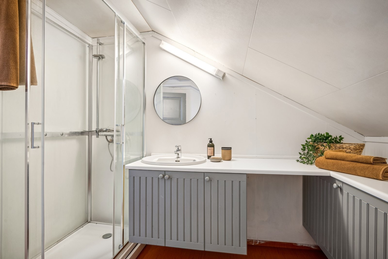 Badet har baderomsinnredning med vask, gulvmontert toalett og dusjkabinett. Panelovn som oppvarmingskilde. Galleribilde