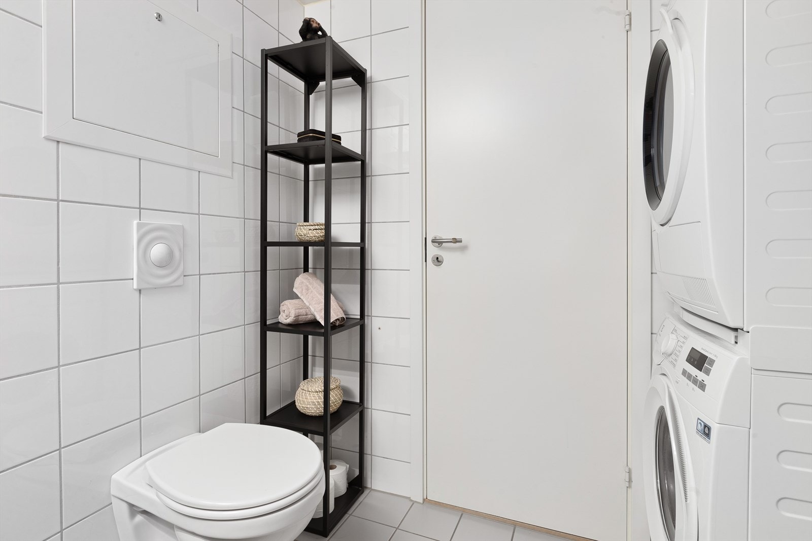 Pent flislagt bad med varmekabler på gulv og opplegg for vaskemaskin og tørketrommel Galleribilde