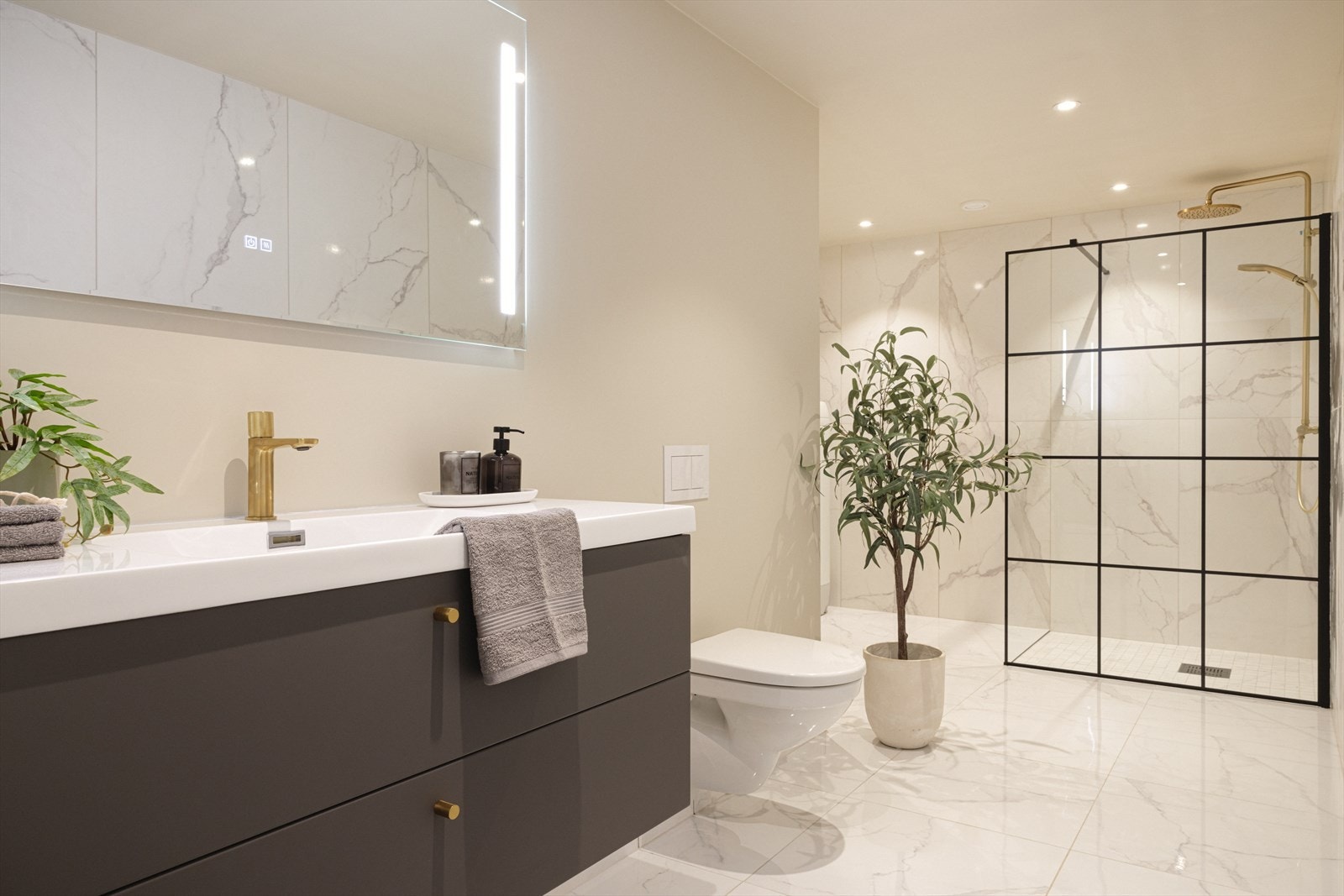 Det største badet måler 10,6 kvm. og har vegghengt toalett, helstøpt servant, skuffer under servant med slette fronter og dusjvegg i klart glass. Det er opplegg for vaskemaskin. Galleribilde