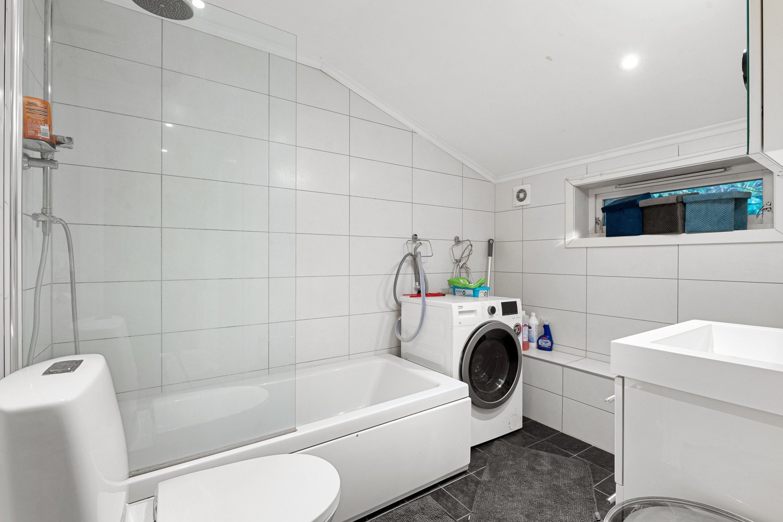 Fint bad som er innredet med servantskap, badekar med dusjvegg og wc. Galleribilde