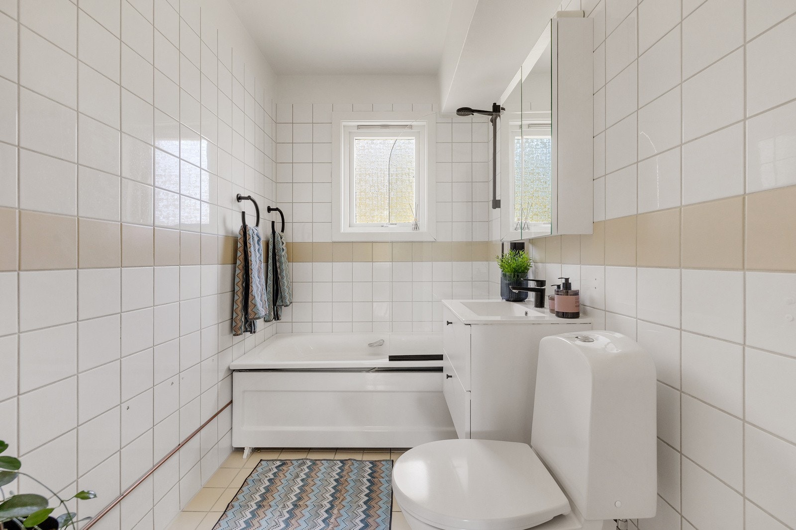 Flislagt baderom hovedsakelig fra 1998, oppgradert med nytt badekar, dusjarmatur, baderomsinnredning og toalett i 2023. Galleribilde