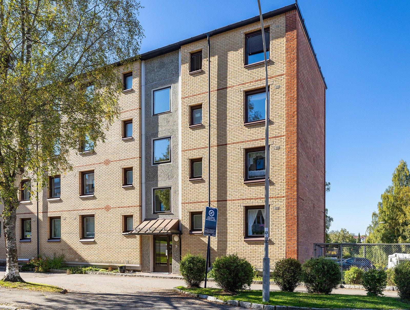 Fasade og inngangsparti. Borettslaget har flere sittebenker plassert rundt om på området. Galleribilde