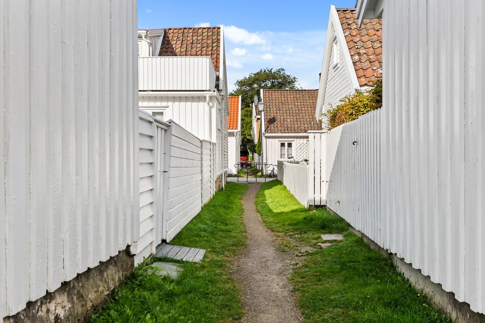 Koselig smau mellom husene i den idylliske trehusbebyggelsen på Sanden Galleribilde