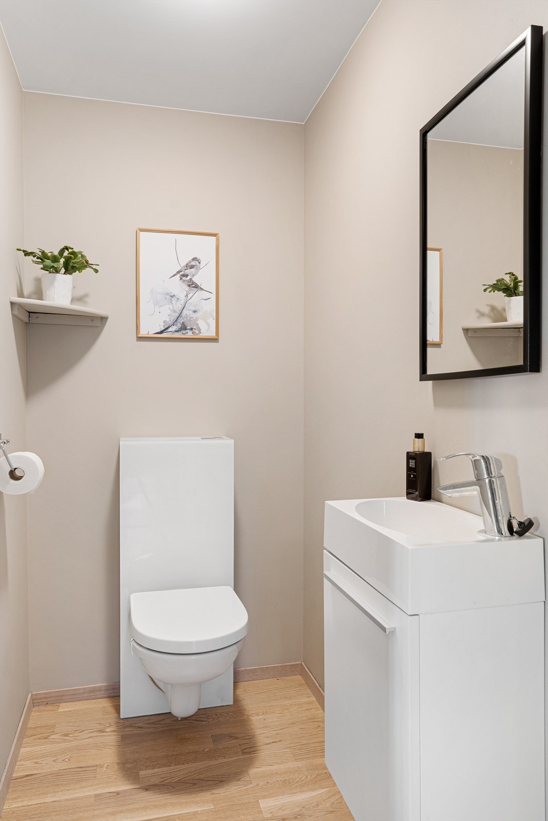 Praktisk gjestetoalett med vegghengt toalett og innredning med servant. Galleribilde