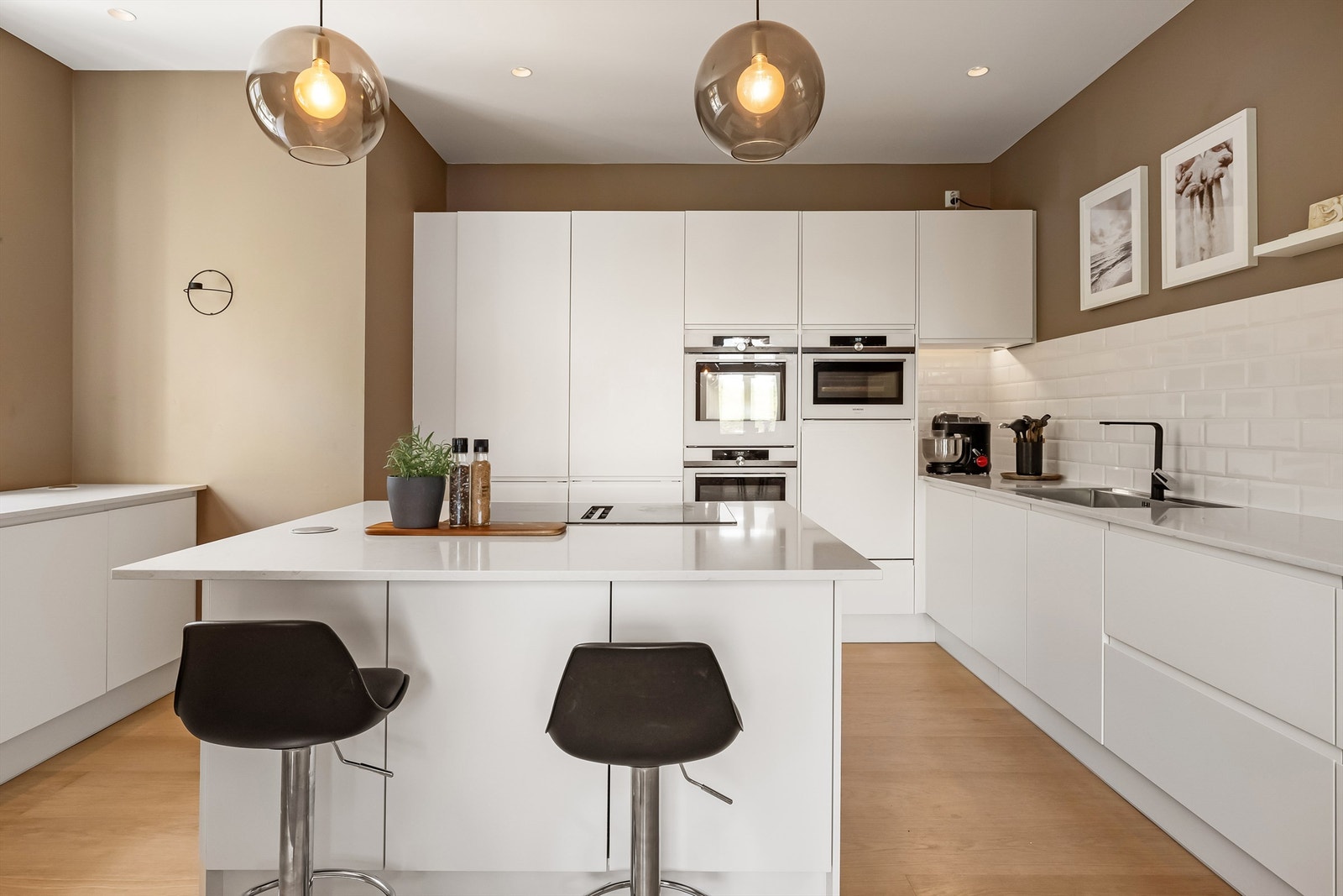 Integrerte hvitevarer med kjøleskap, fryseskap, steikeovn, oppvaskmaskin og micro. Ventilator i platetopp på kjøkkenet. Galleribilde