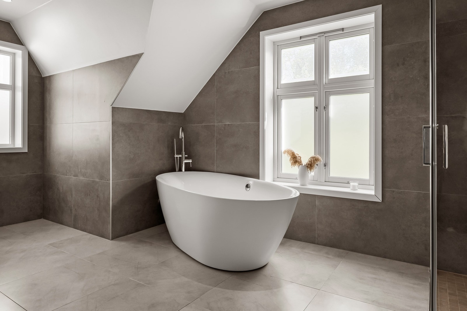 Delikat baderom i 2 etasje med flott badekar og stort dusjhjørne. Baderommet er av meget generøs størrelse. Galleribilde