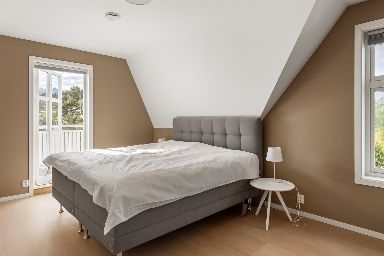 Hovedsoverom med utgang til balkong/veranda. Ett av totalt 4 soverom i boligens hoveddel. Totalt innehar boligen 7 soverom medregnet soverom i utleiedeler i underetasjen. Galleribilde