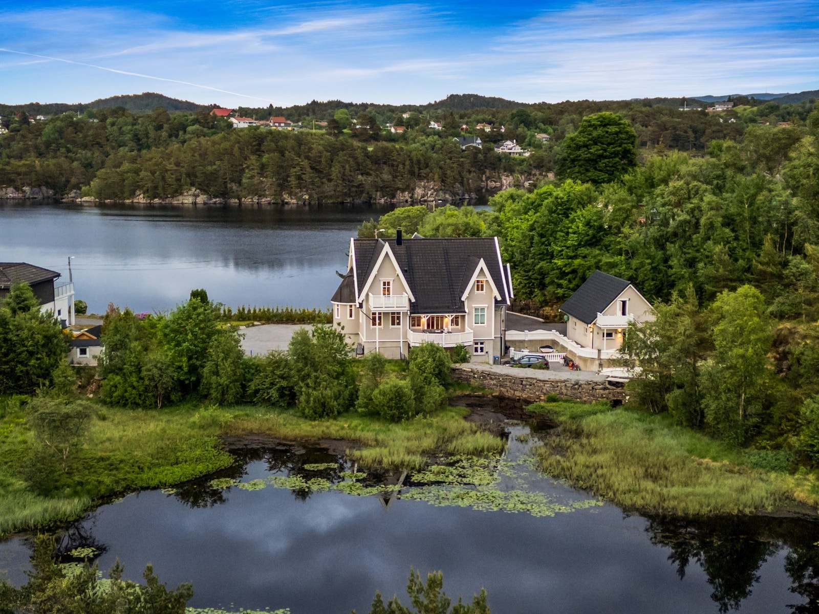 Koselig tjærn like bak bolighuset med ender som plutselig kan komme inn i hagen for en matbit. Galleribilde