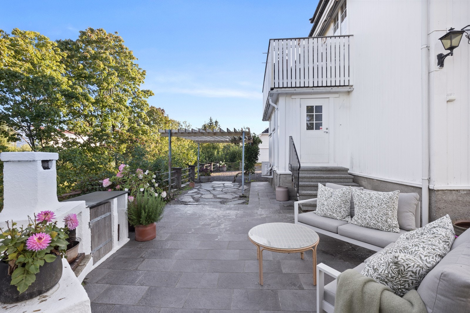 Hyggelig steinbelagt uteplass med plass til en loungeløsning Galleribilde