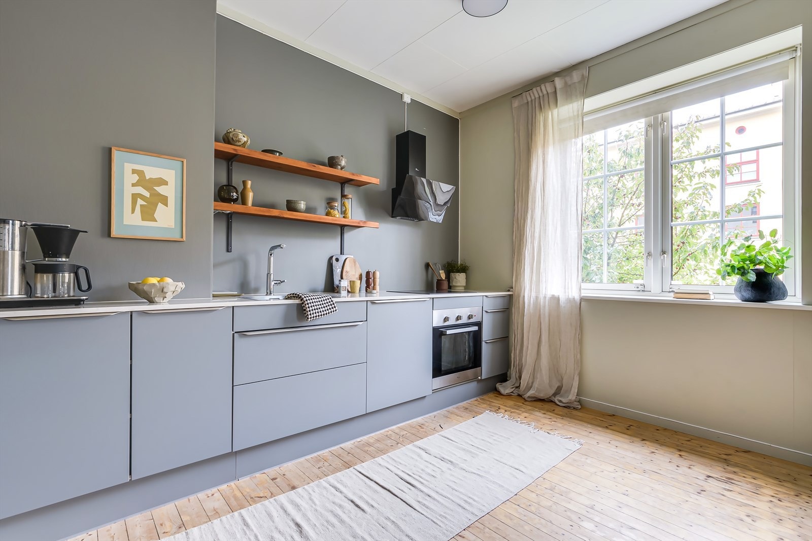 Kjøkkeninnredning består av grå slette fronter. Benkeplate av heltre og kompositt. Integert oppvaskmaskin, stekeovn, platetopp og løst kjøl/frys. Galleribilde