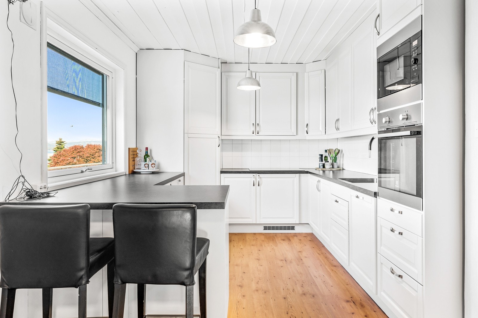 Køkkenet har en innredning med hvite profilerte fronter og laminat benkeplate, skiftet i 2016 Galleribilde