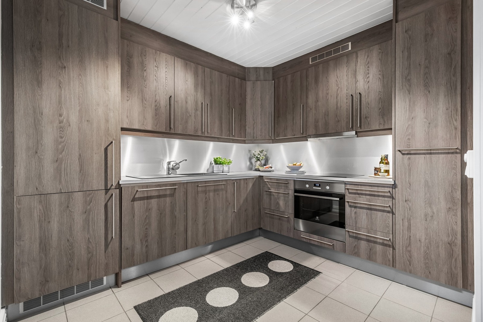 Kjøkkenet har integrert induksjonsplatetopp, stekeovn, oppvaskmaskin og kjøl/fryseskap Galleribilde