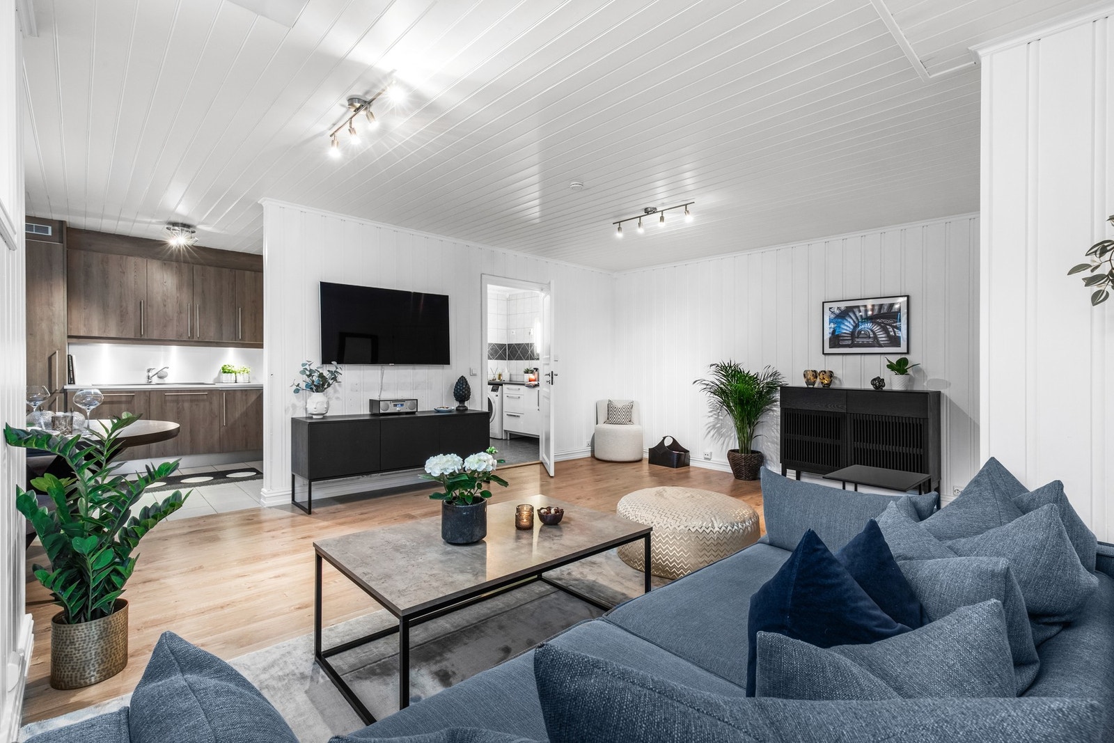 Stuen i leiligheten fremstår som lys og delvis åpen løsning mot kjøkkenet skaper en sosial atmosfære Galleribilde