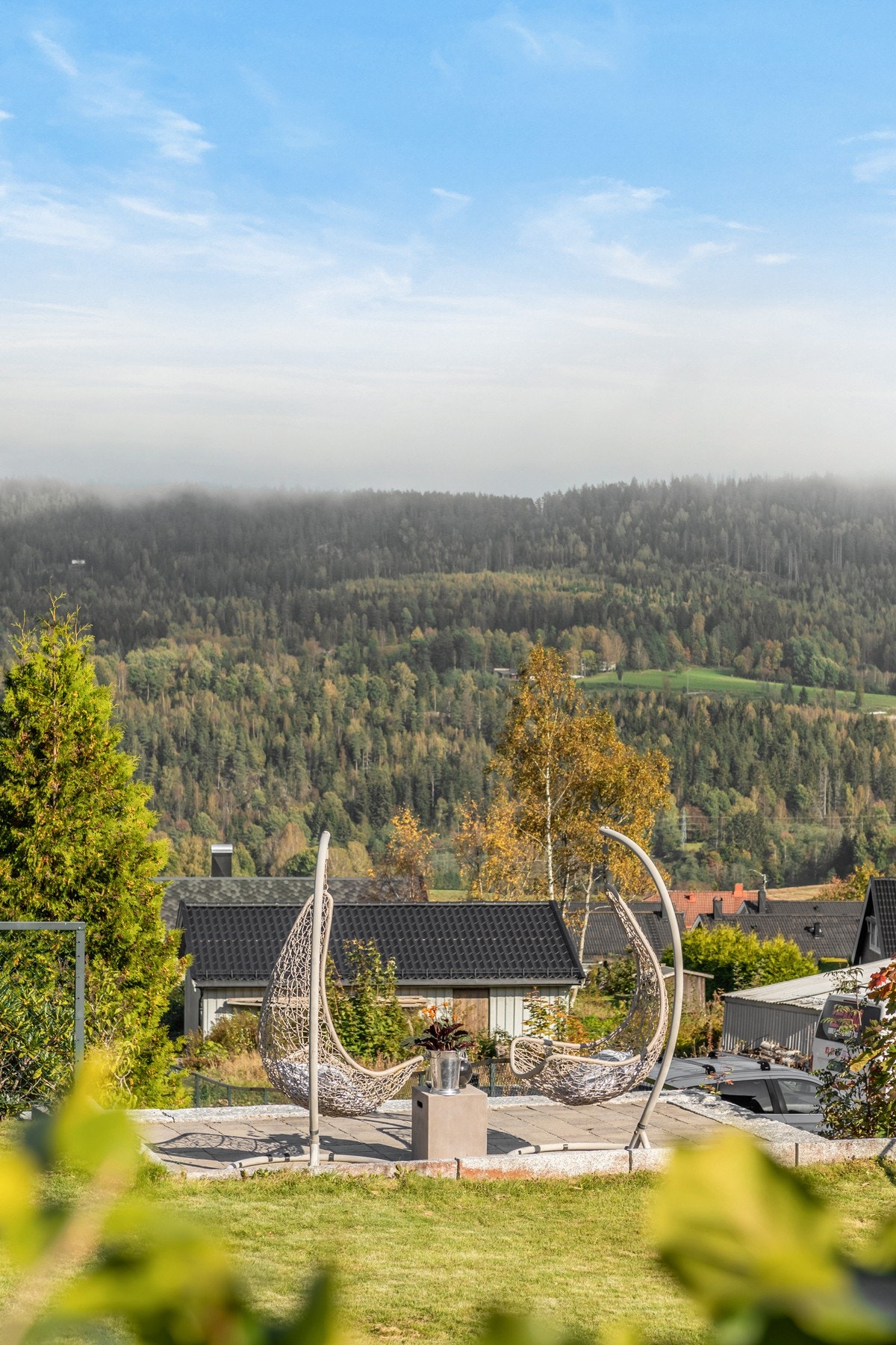 Tomten skråner mot nord, men rundt huset er det planert flatt, slik at man enkelt kan nyte solrike dager med fin utsikt Galleribilde