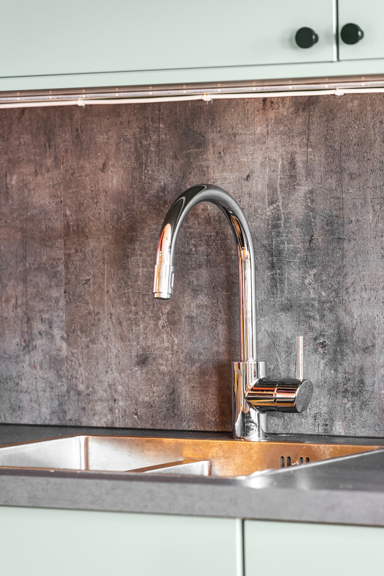 Matchende plate over benken med nedfelt vaskekum. Lysstriper over vaskebenken, belysning i ventilator og spotbelysning i taket, samt godt med dagslys fra store vinduer, gjør arbeidssonen ekstra lys og trivelig. Galleribilde