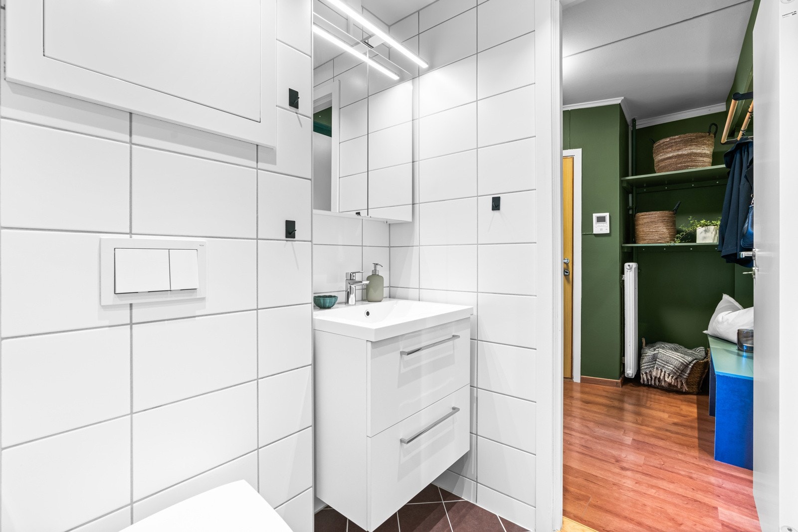 Innredningen består av en heldekkende servant på hvit skuffeseksjon, speilskap med overlys. Galleribilde