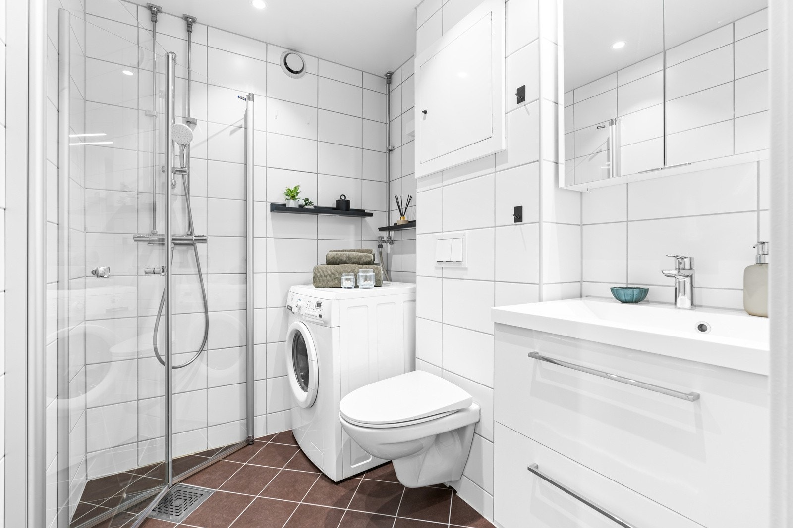 Badet er moderne og pent - totalrehabilitert i regi av borettslaget i 2019. Fliser på gulv med gulvvarme og downlights i glatt, hvitmalt himling. Galleribilde