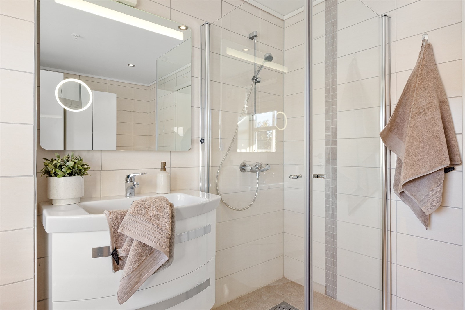 Bad med vegghengt toalett, dusjhjørne og servantskap Galleribilde