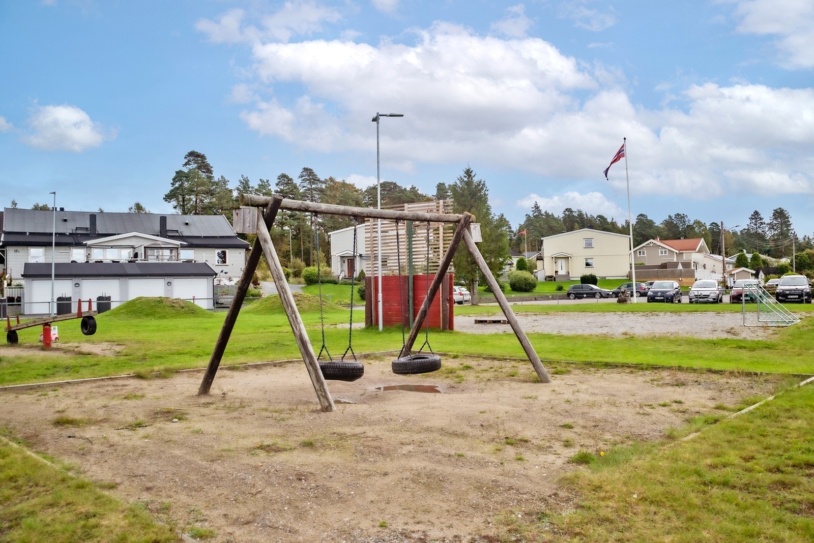 Det er også en liten grusbane med fotballmål. Tomten er ellers opparbeidet med gressplen, grus, asfalterte områder, trær, busker og div. beplantning. Galleribilde