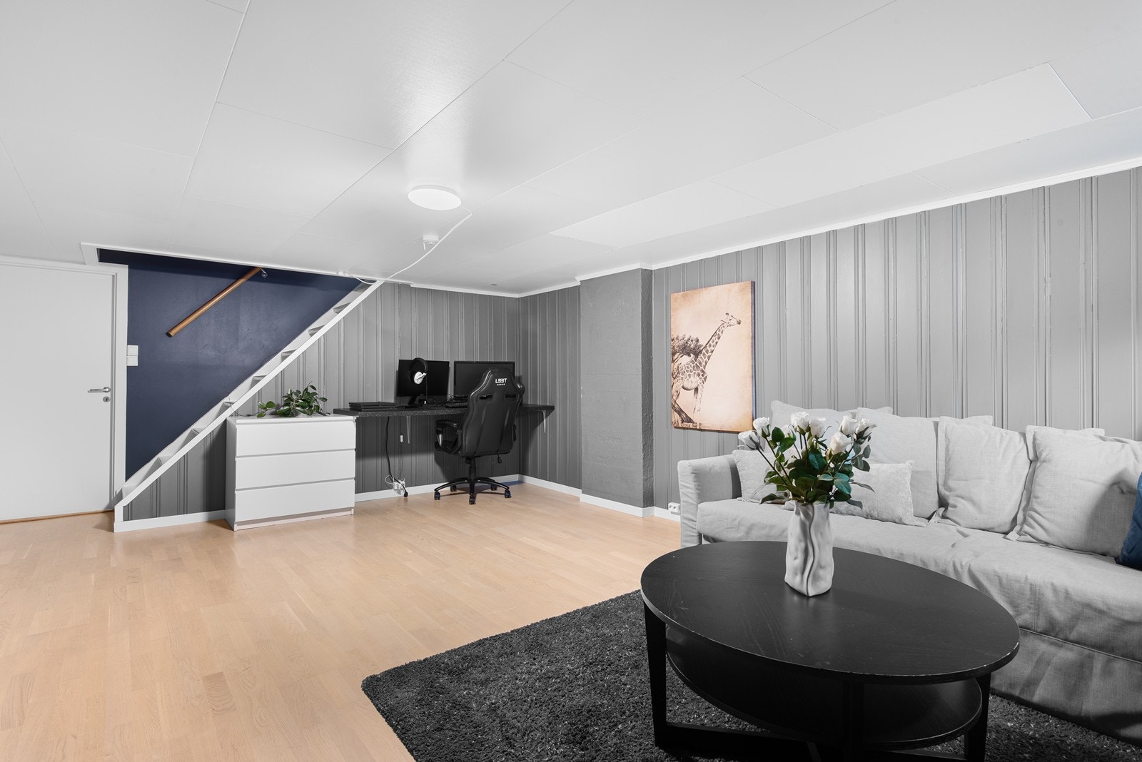 Rom innredet som stue har samme parkettgulv som resten av boligen, malt panel på vegger og har flere bruksmuligheter. Galleribilde