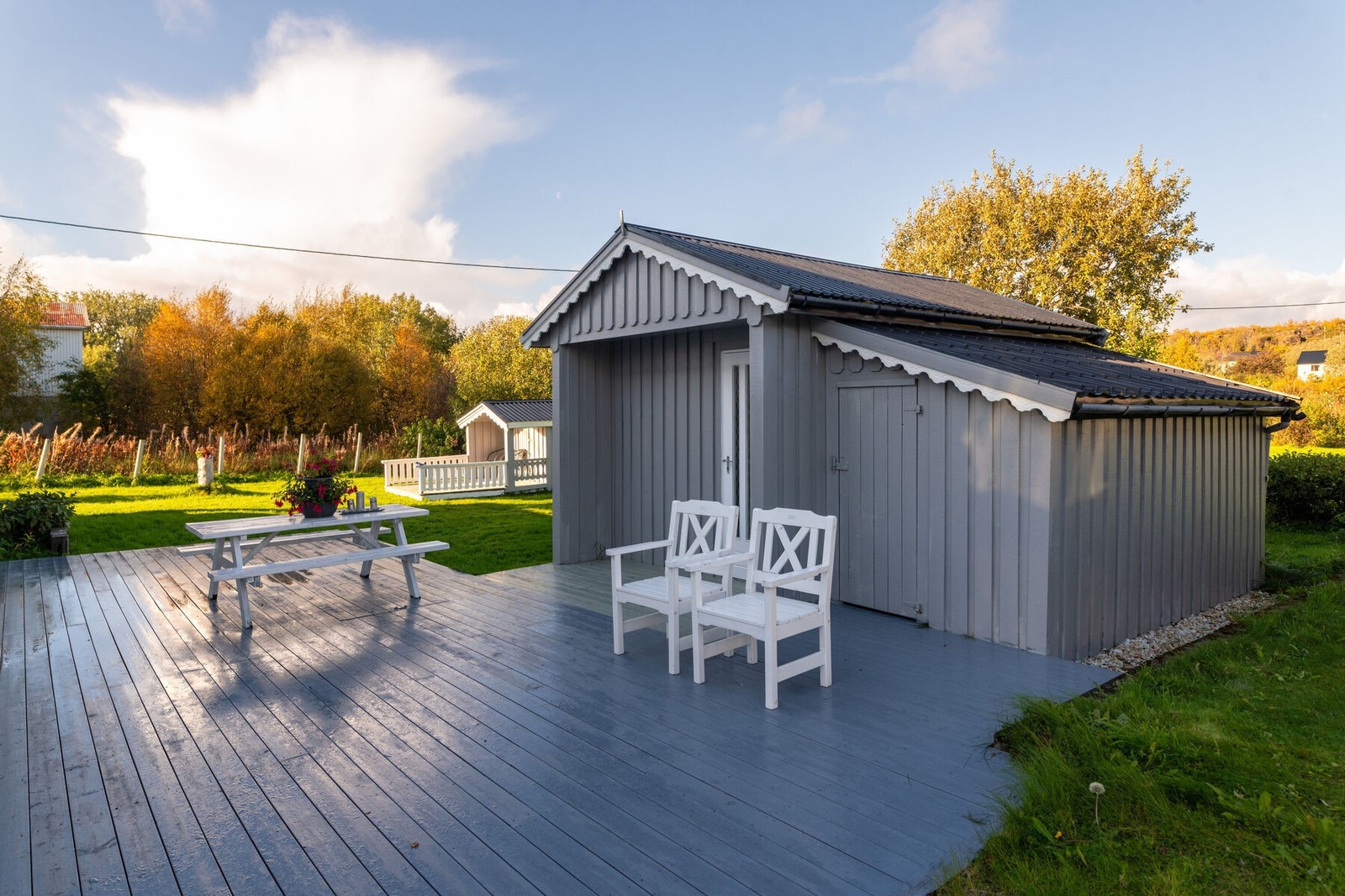 Uteområdet er flott opparbeidet med platting, utebod, dukkehus og stor hage. Galleribilde