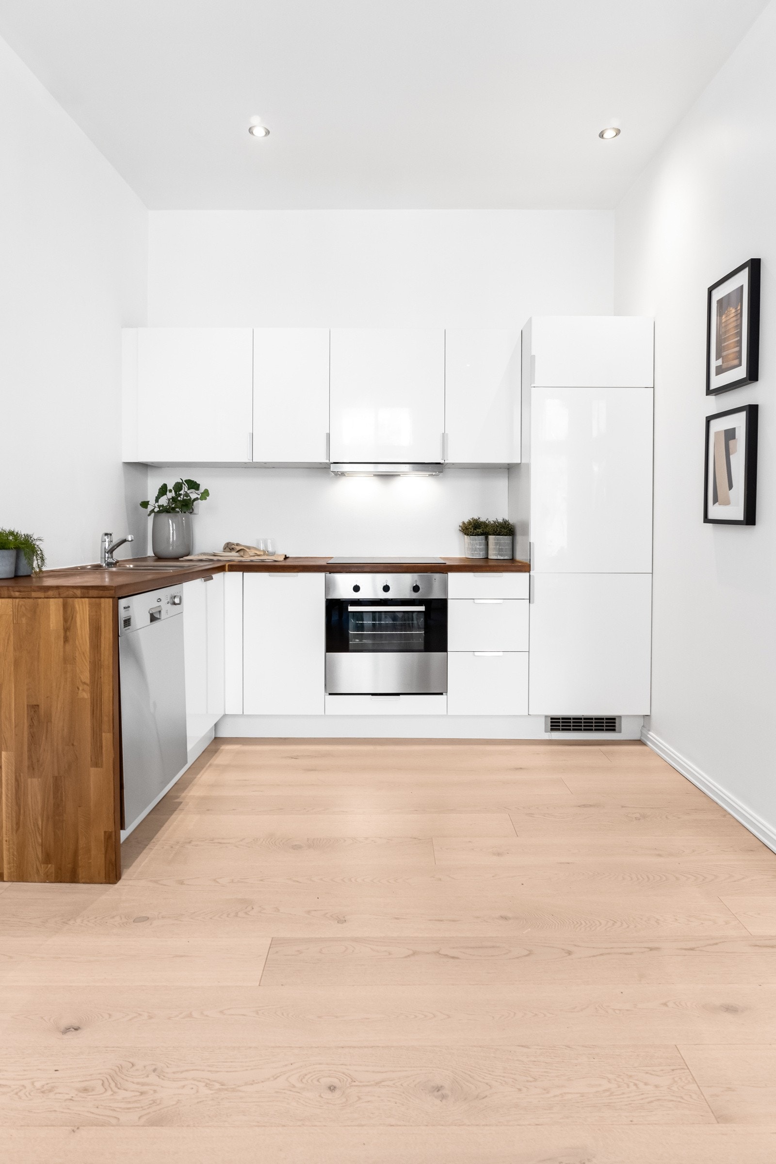 Stilren kjøkkeninnredning med slette fronter og heltre benkeplate. Galleribilde