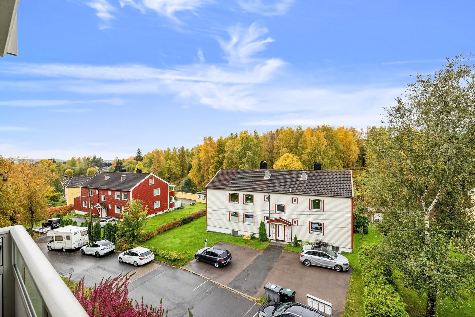 Utsikt fra balkongen over hyggelig småhusbebyggelse. Mye lys og luft mellom bebyggelsen Galleribilde
