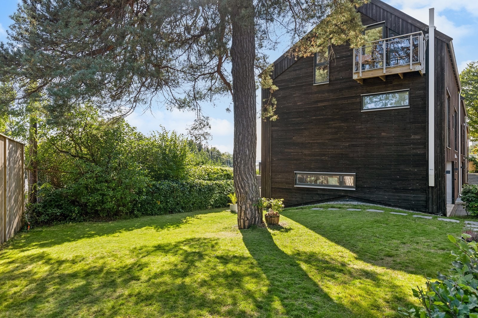 Eneboligen har eksklusiv bruksrett til en frodig hage med gressplen og planter. Galleribilde