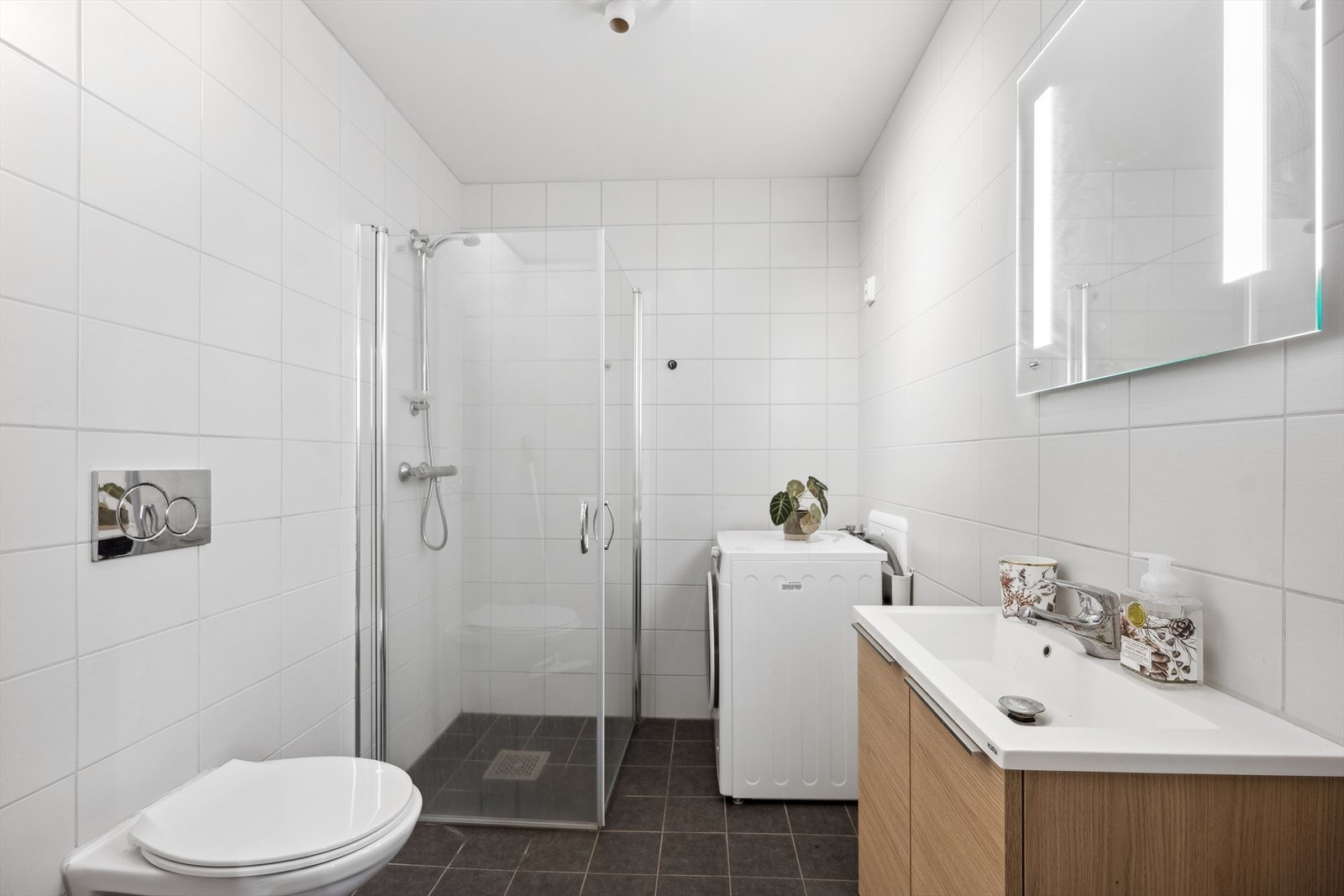 Bad III i u.etg er delikat og flislagt med opplegg for vaskemaskin. Galleribilde