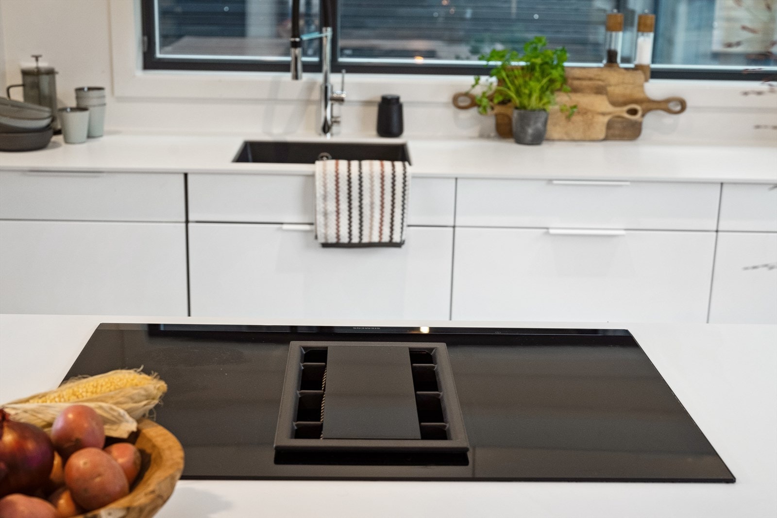 Integrert og praktisk kjøkkenventilator i kokketoppen på den frittstående kjøkkenøyen. Galleribilde