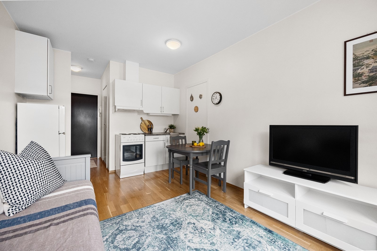 Stuen har god plass til å innrede med både sovesofa, spisebord og TV-seksjon. Her består overflatene av slette malte vegger og parkett på gulv. Galleribilde