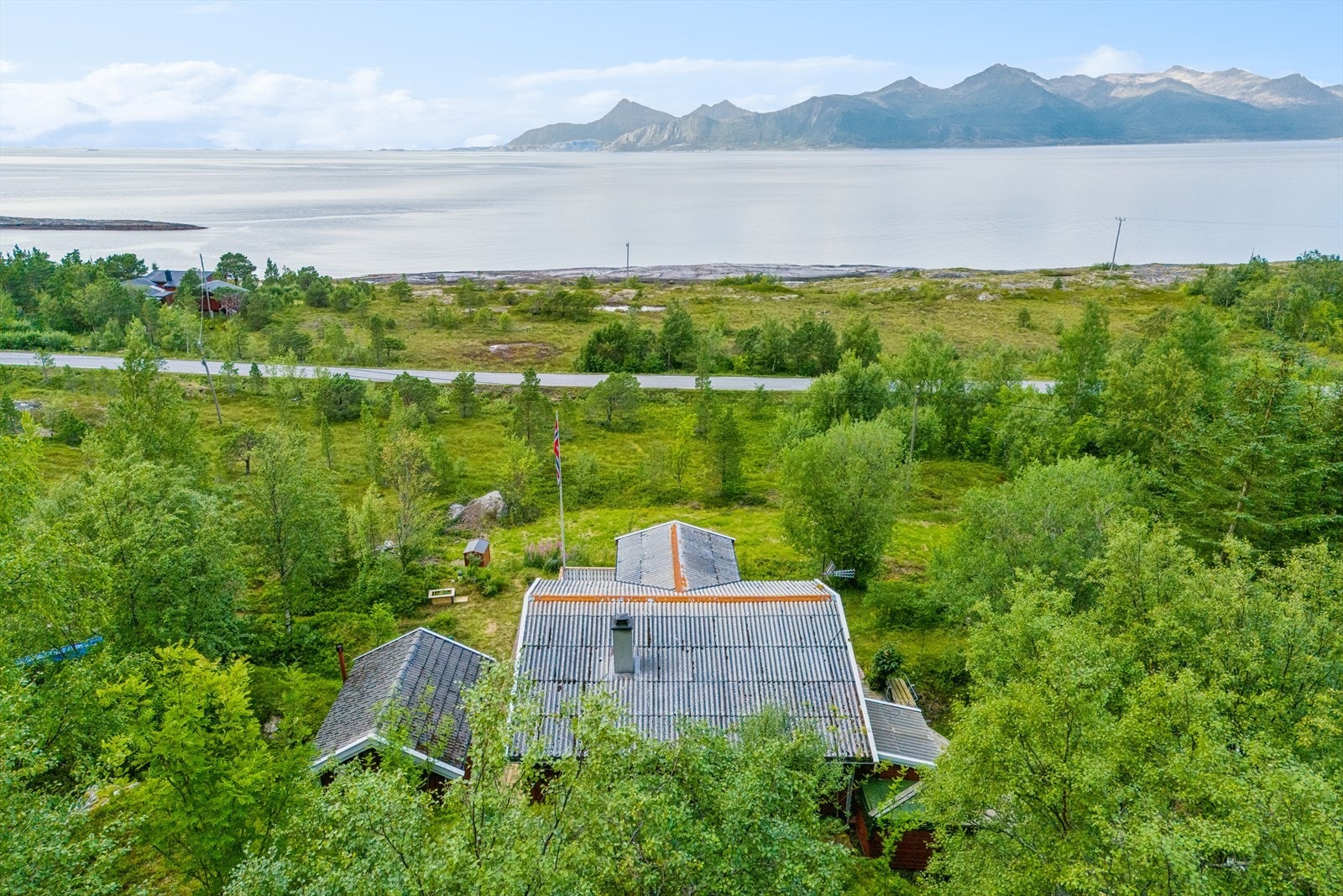 Hytten har en fin plassering i terrenget på oversiden av veien og vegetasjonen rundt sørger for en usjenert beliggenhet - Like på andre siden av veien ligger sjøen med fine svaberg hvor en kan nyte godværsdager Galleribilde