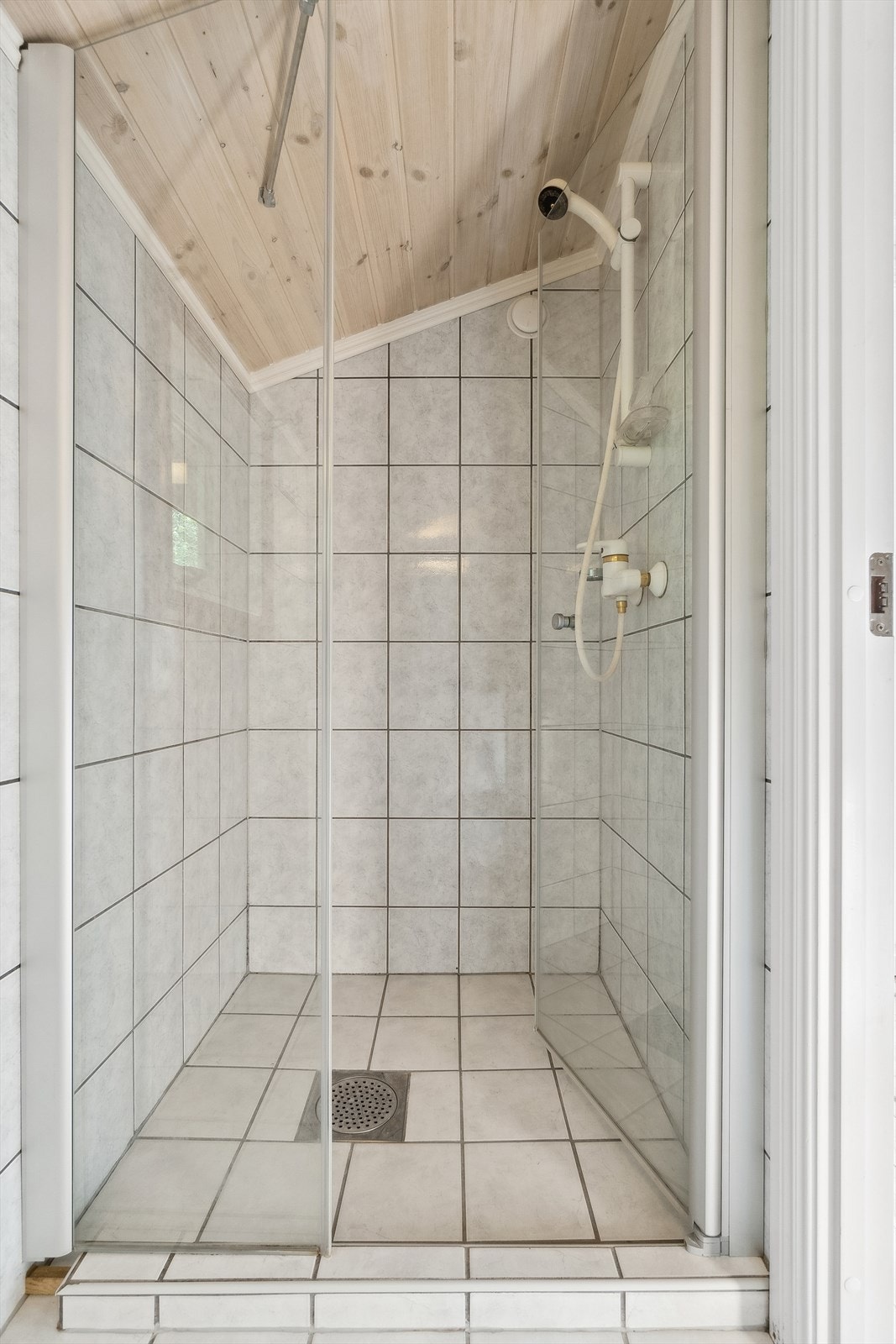 Rommet er utstyrt med dusjnisje og baderomsinnredning bestående av servant, skap, speil og lys. Galleribilde