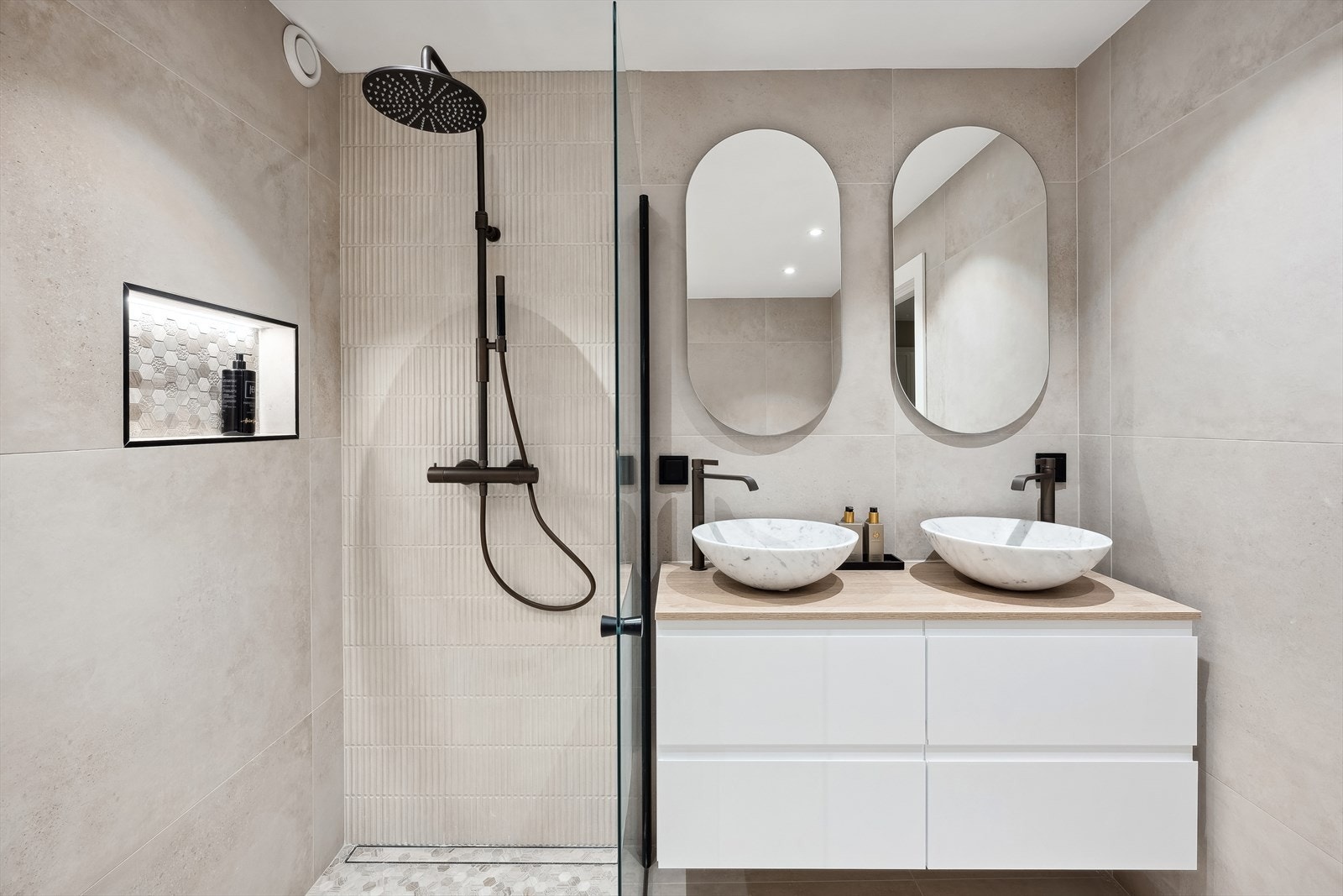 Bad 1 har armaturer i bronse fra Tapwell. Mosaikk i marmor på gulv i dusjsonen og i nisjene. Lekre Carrara marmorservanter fra Ulfven Galleribilde