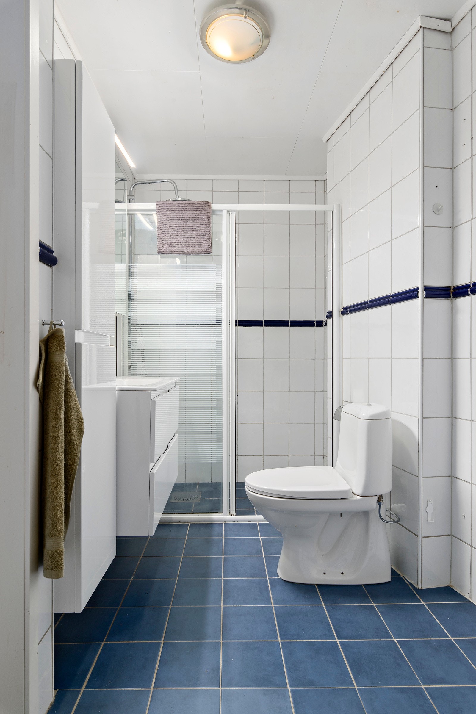 Badet er innredet med wc, dusjhjørne, servant med innredning og muligheter for å ha både vaskemaskin og tørketrommel. Galleribilde