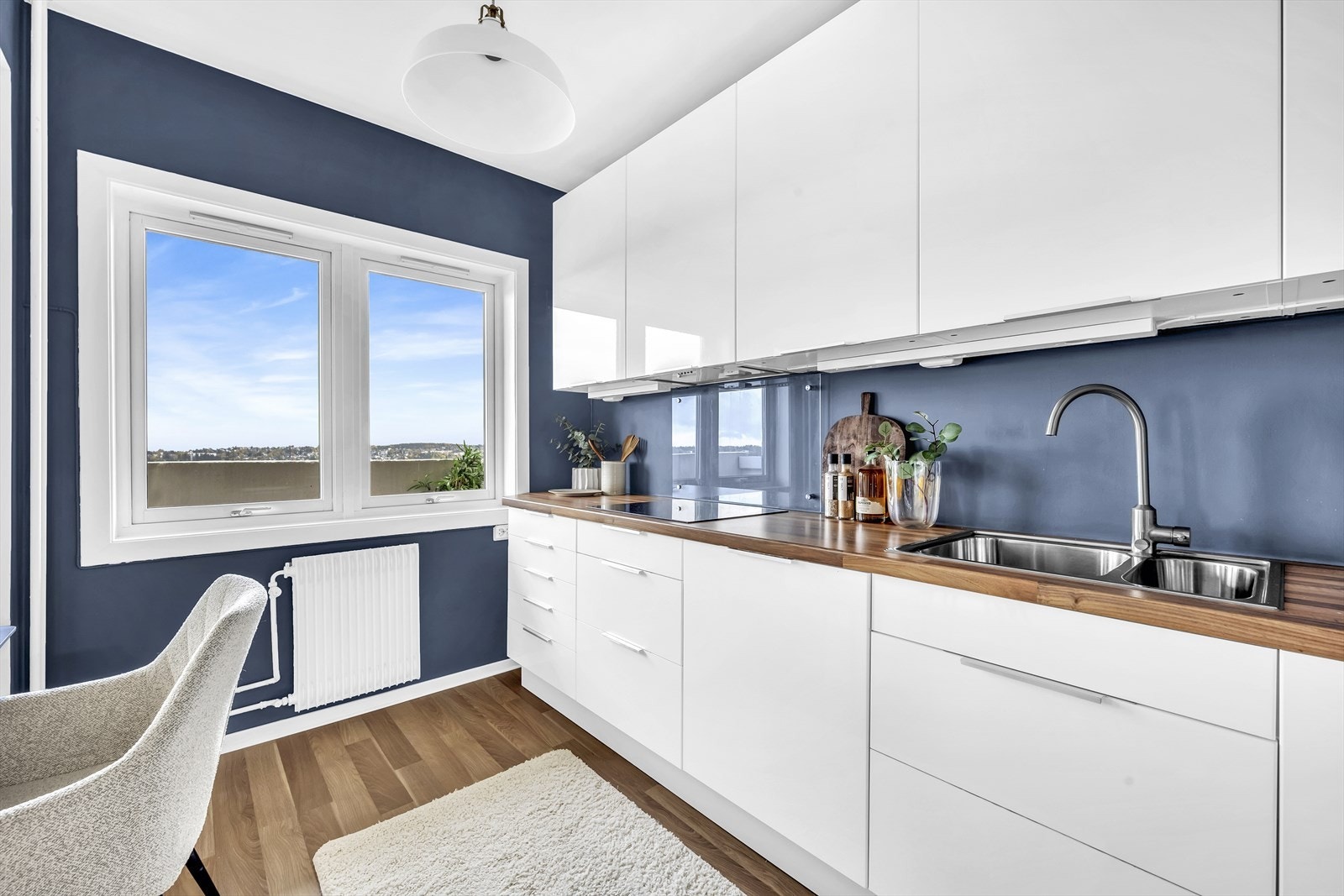 Lys innredning med slette, høyglans fronter og benkeplate i laminat. Galleribilde