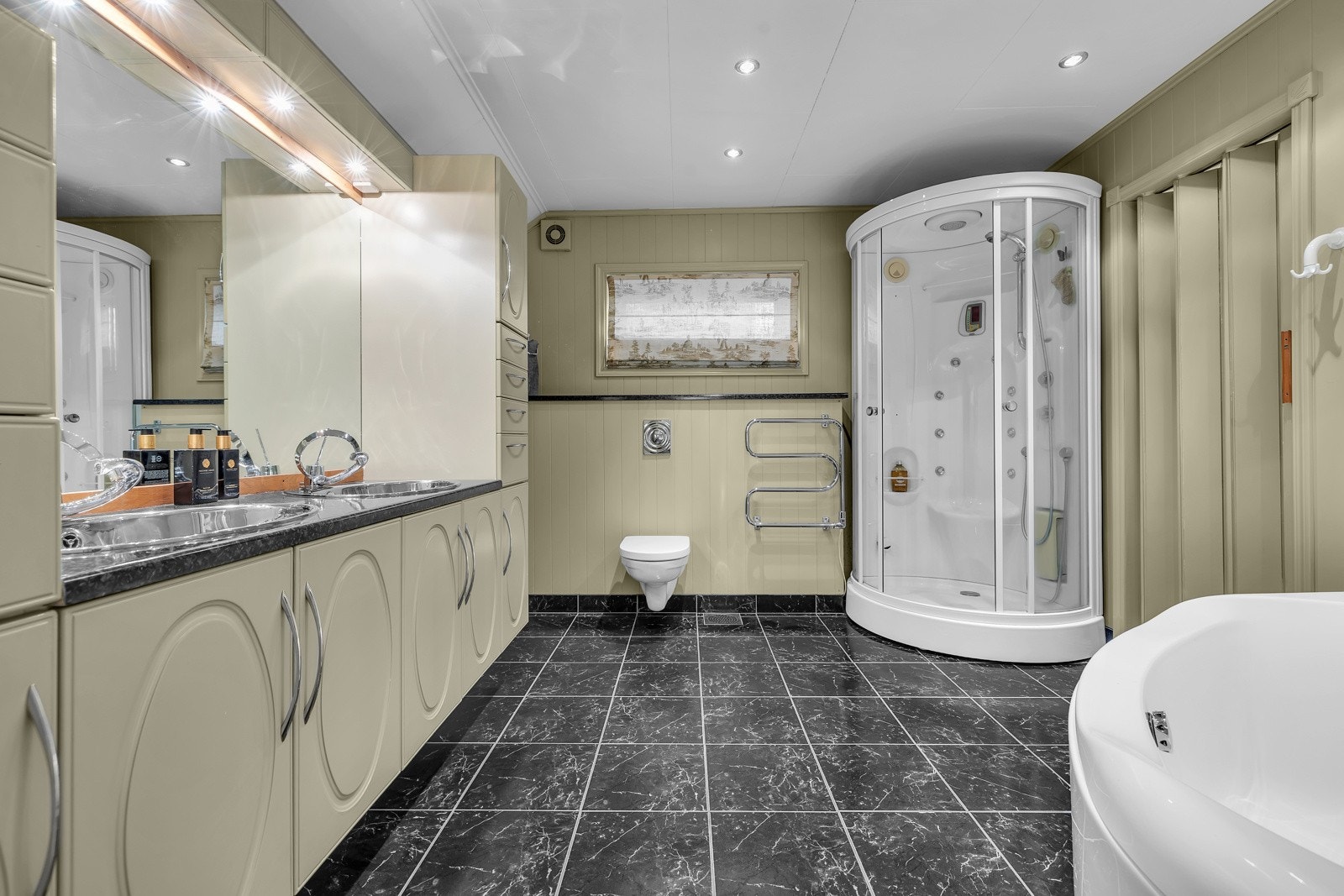 Fra både walk-in garderoben og gangen er det inngang til dette store badet Galleribilde