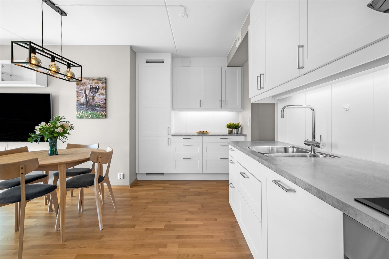 Kjøkkenet har glatte fronter og laminat benkeplate med nedfelt vask. Videre er det integrert induksjonstopp, stekeovn, oppvaskmaskin og kjøl/fryseskap. Galleribilde