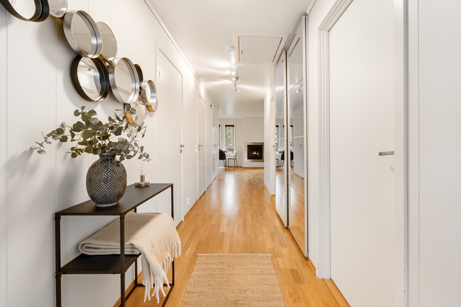 Tiltalende entre/gang med trestavs parkett på gulv og lysmalte veggflater som gir et godt førsteinntrykk av leiligheten. Det er bygget inn en stilren skyvedørsgarderobe i vegg som gir god oppbevaringsplass og bidrar til en ryddig og funksjonell inngang. Galleribilde
