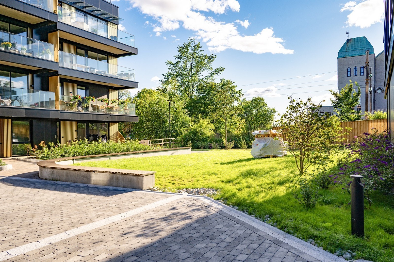 Pent opparbeidet bakgård hvor det er etablert klatrestativ og sandkasse etter at bildet ble tatt Galleribilde