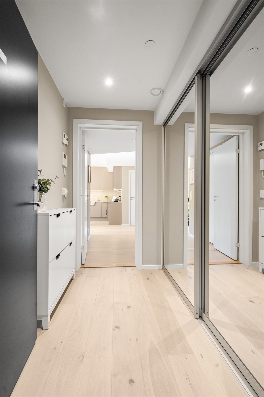 Lys og innbydende entré med god lagringskapasitet i plassbygd skyvedørsgarderobe Galleribilde