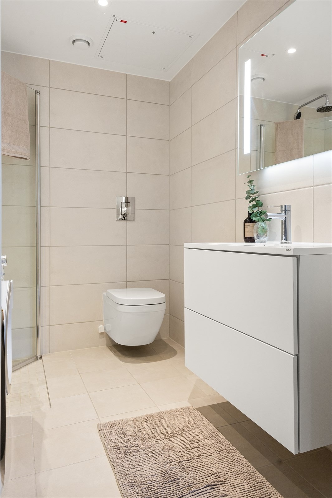 Boligens andre og største baderom er også lekkert flislagt med vannbåren varme i gulv og downlights i himling Galleribilde