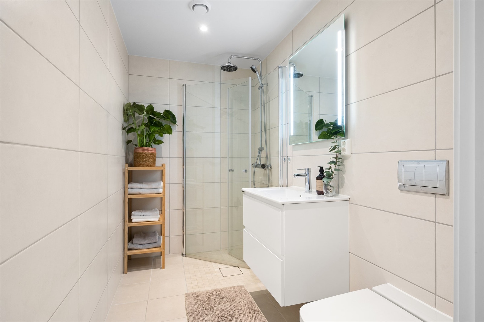 Med direkte tilgang fra soverommet er et innbydende og meget romslig bad med gråmelerte fliser på gulv og vegg samt vannbåren varme i gulv og downlights i himling Galleribilde