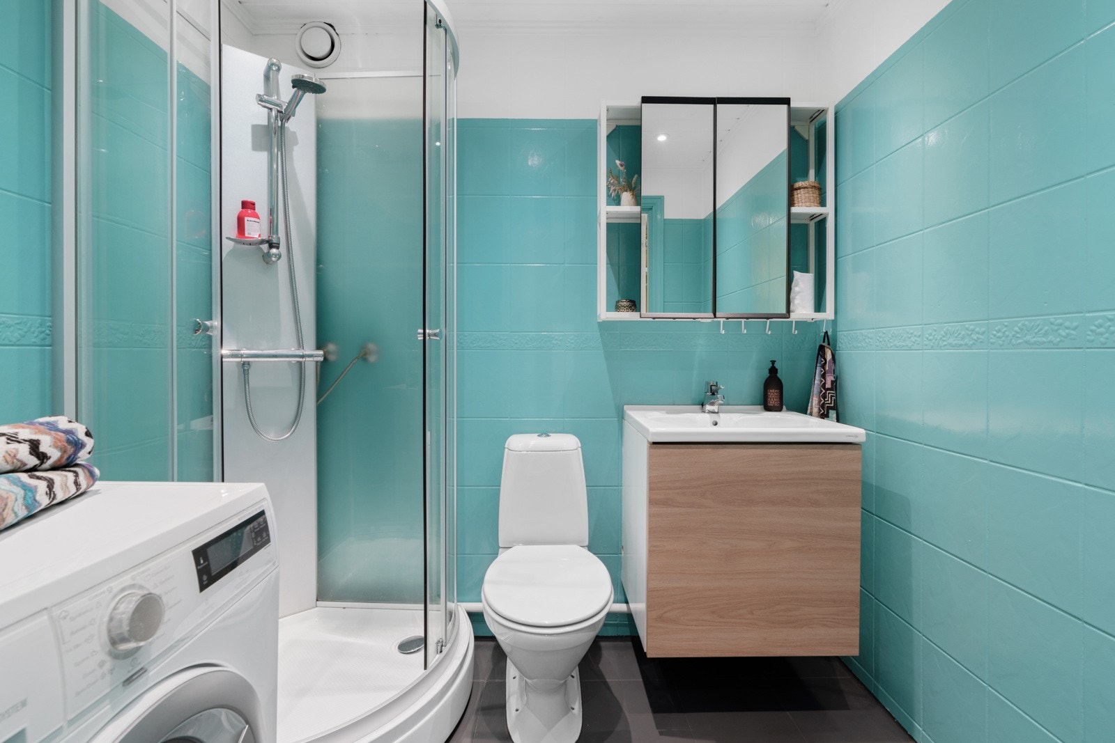 Romslig, flislagt bad med nytt duskabinett og nye skap fra 2021 - Det er opplegg for vaskemaskin, varmekabler i gulv og downlights i tak Galleribilde